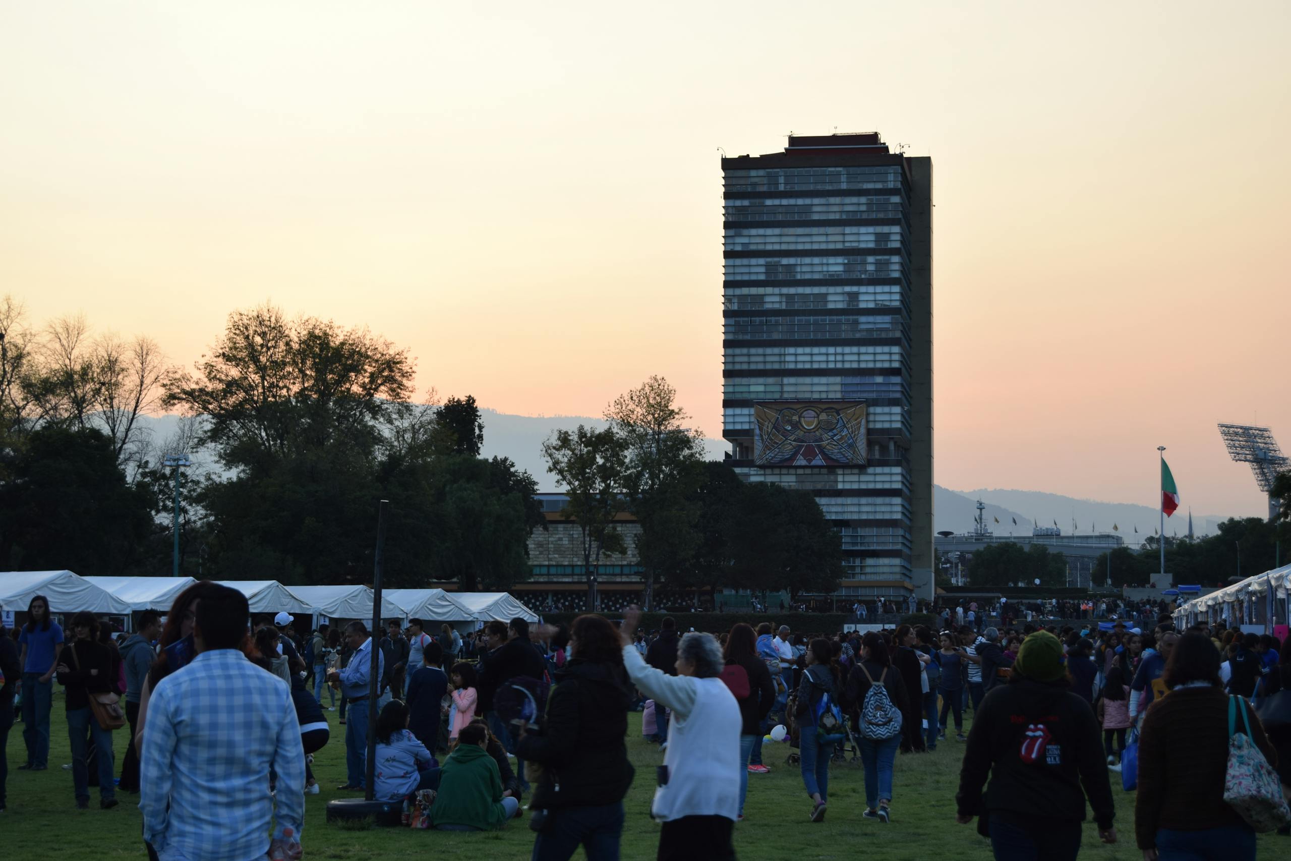 People enjoying a lively sunset event at UNAM University in Mexico City.